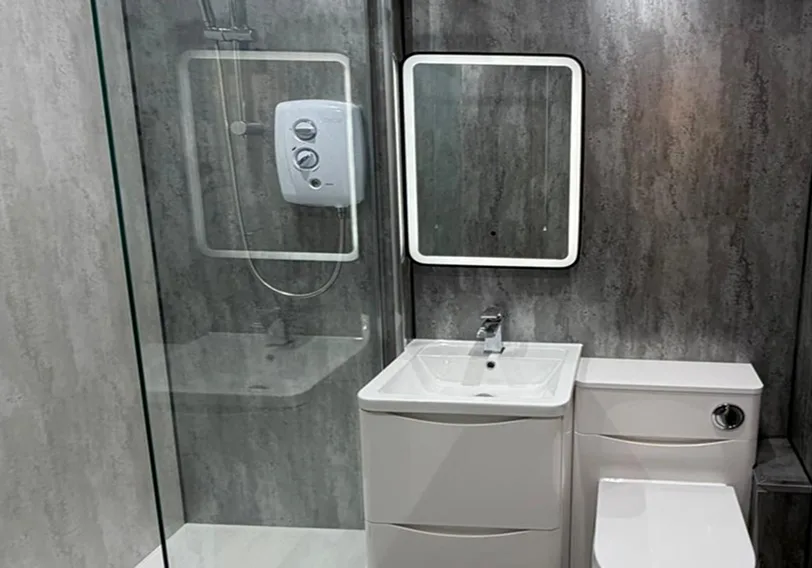 Essential bathroom package with practical bath, walk-in shower, grey wood-effect tiles, white vanity unit and LED mirror for Glasgow family home