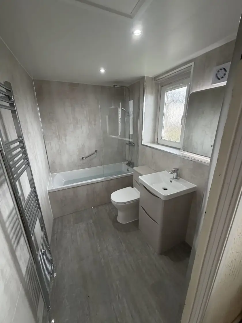 Finished grey bathroom with walk-in shower, vanity unit and white suite